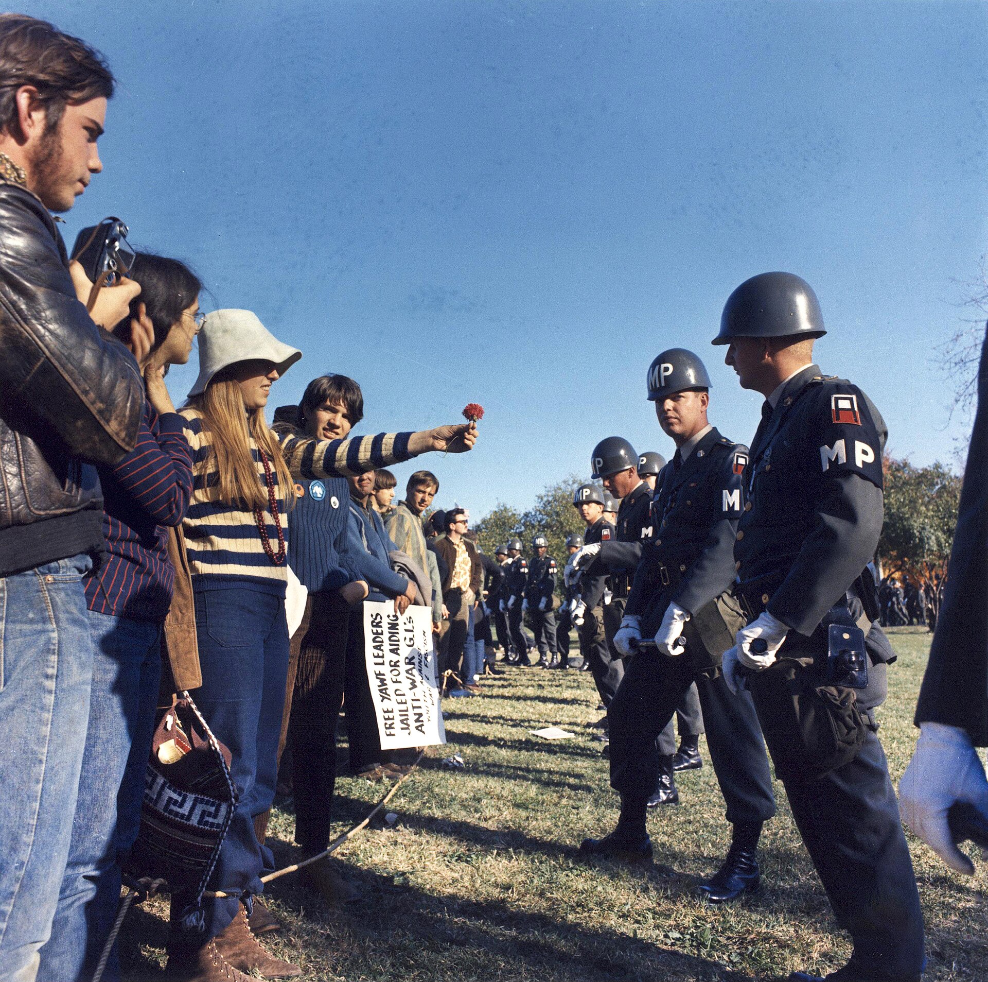 1967年10月、ペンタゴンでMPに花を差し出す反戦デモ参加者。支給品の軍服が、反戦の意思表示の場に現れた時代（米国防総省 S.Sgt. Albert R. Simpson 撮影／パブリックドメイン）